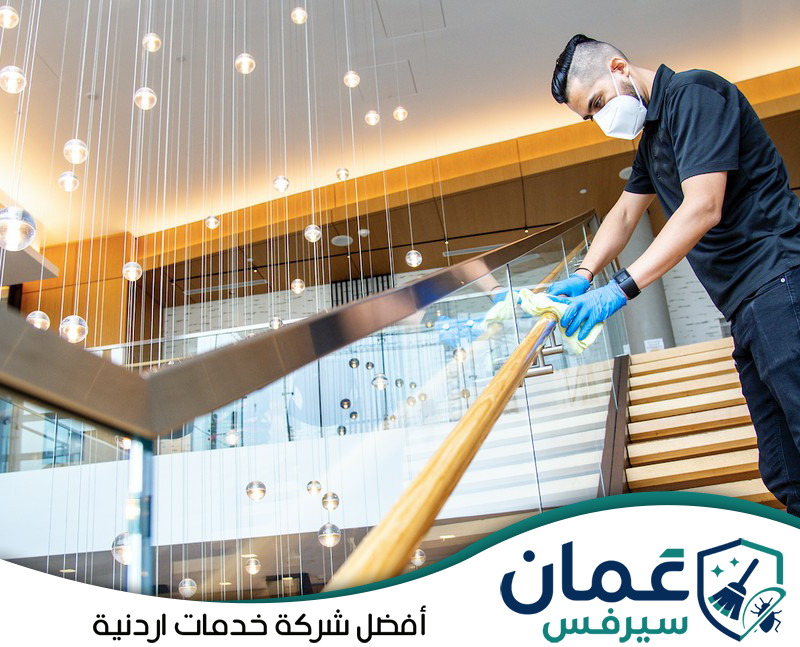 اطلب تنظيف المناطق المشتركة في الفندق مع عمان سيرفس0798779667. عامل ينظف الدرابزين والأسطح المشتركة داخل الفندق ضمن برنامج تنظيف دوري للمناطق كثيرة الاستخدام.