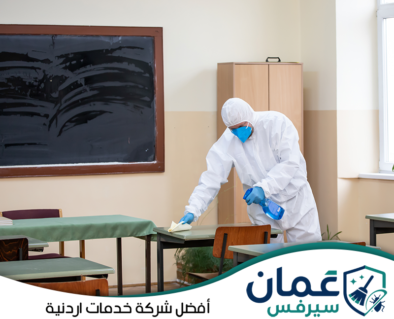 احجز تنظيف وتعقيم مدرستك مع عمان سيرفس0798779667. عامل يعقم طاولات الفصل الدراسي ضمن خدمات تنظيف المدارس في الأردن.